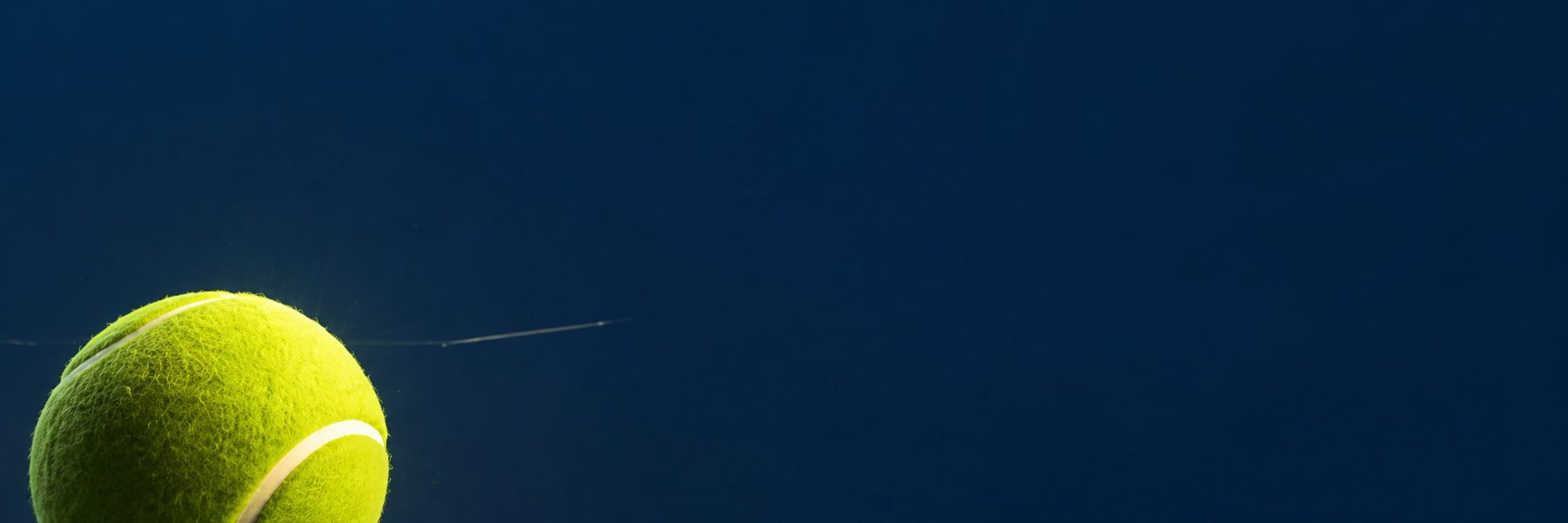 Yellow tennis ball with white stripe on dark blue background